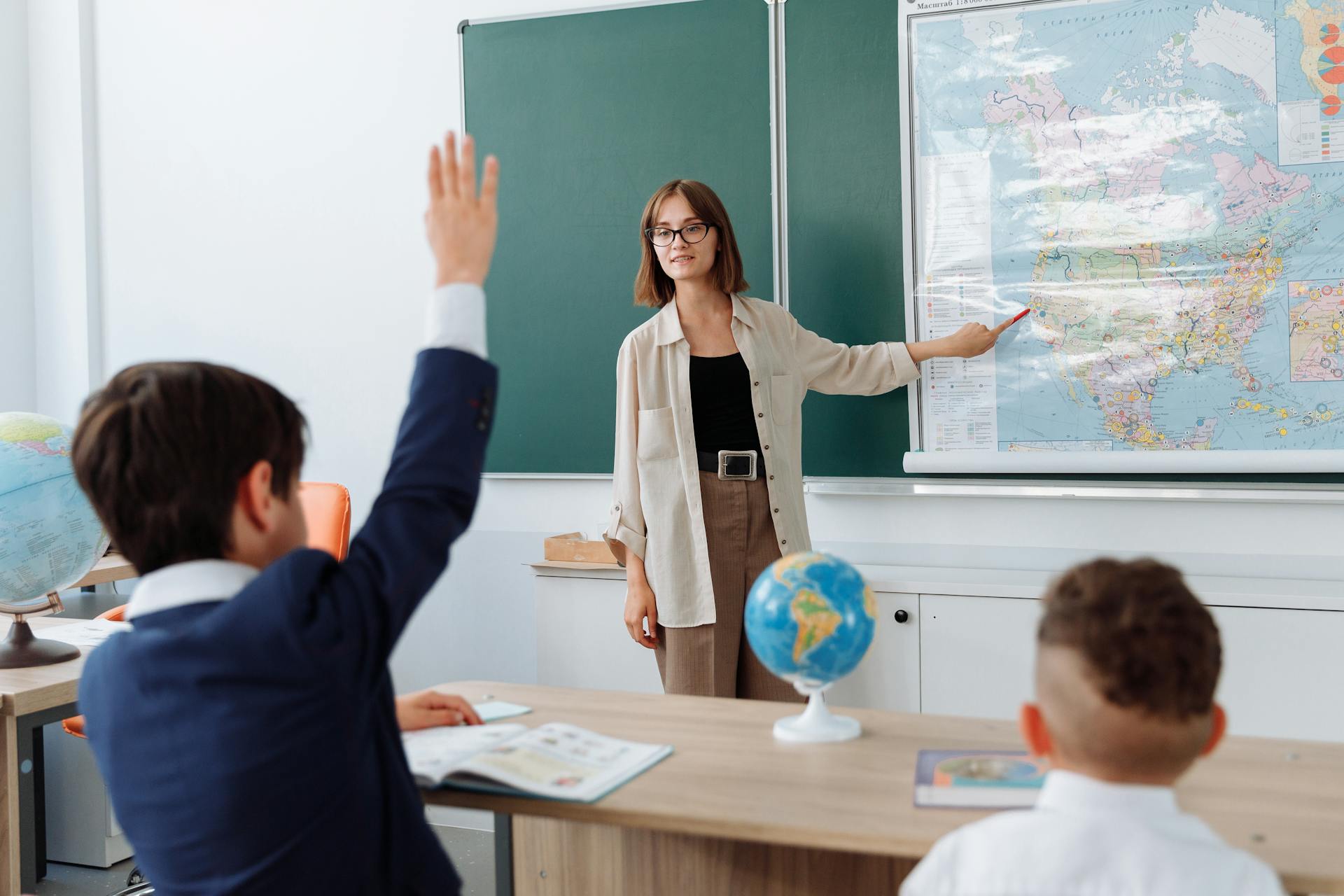 A little boy raising his hand in Geography class | Source: Pexels