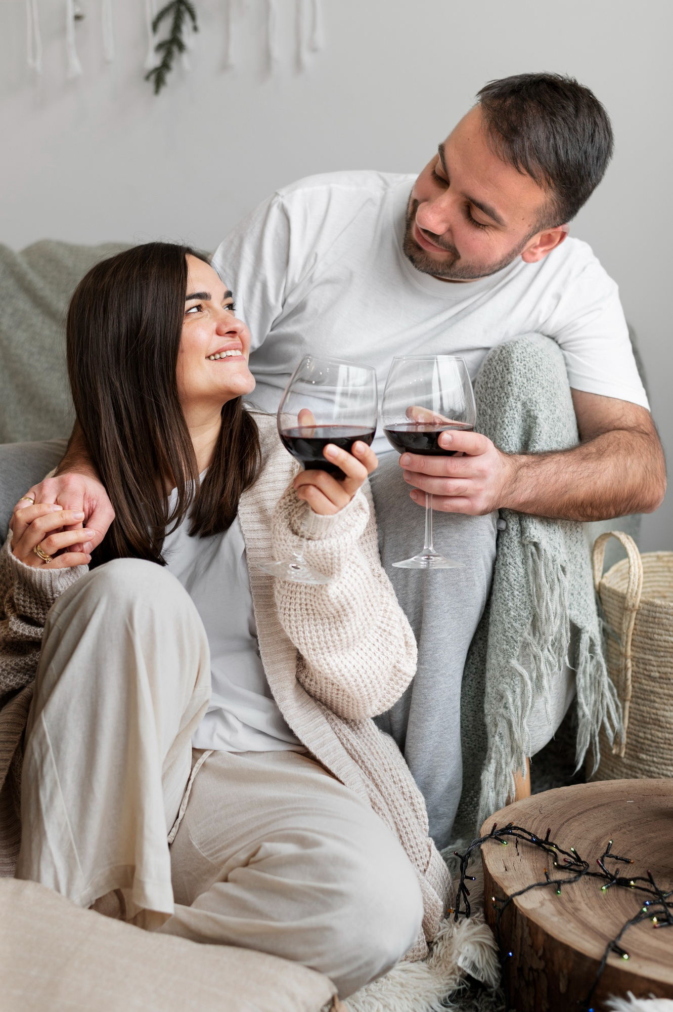 A loving couple talking and enjoying their drinks at home | Source: Freepik