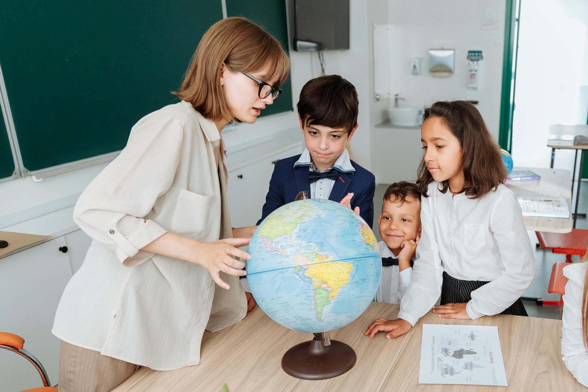 A Geography teacher with students in a classroom | Source: Pexels